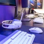 Close-up of a gaming setup featuring a white headset, computer mouse, and keyboard with a vivid lighting ambiance. – all-white gaming pc build