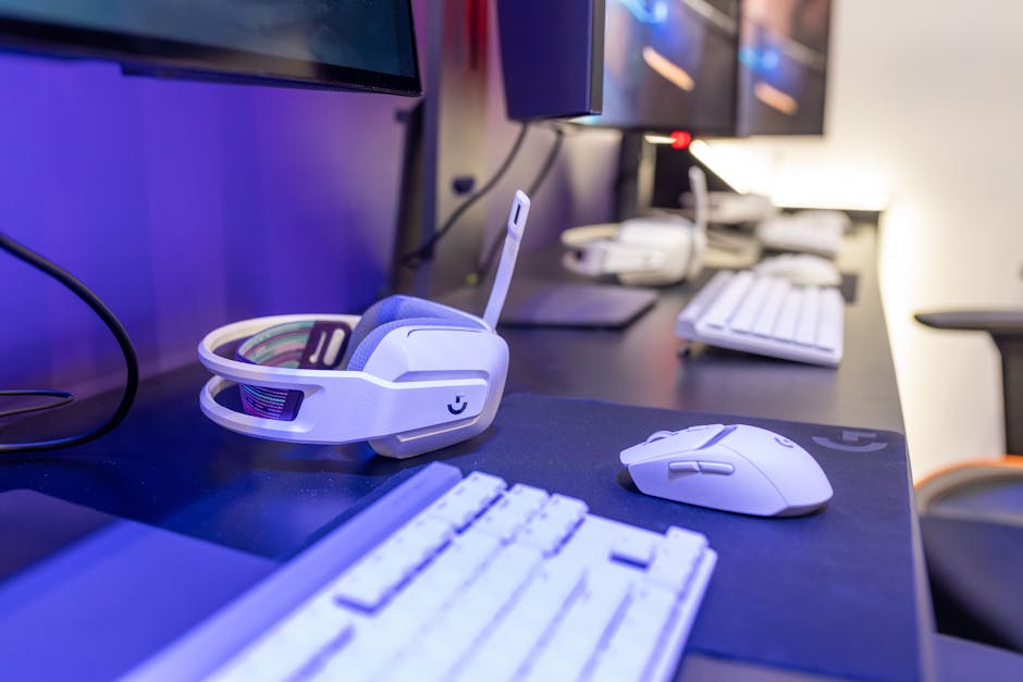 Close-up of a gaming setup featuring a white headset, computer mouse, and keyboard with a vivid lighting ambiance. – all-white gaming pc build