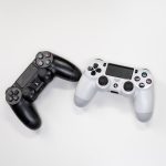 Flat lay of black and white gaming controllers against a white backdrop, perfect for gaming enthusiasts. – Assassin's Creed: Black Flag Resynced