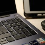 Close-up of laptop keyboard, wireless mouse, and tablet illustrating modern workspace technology. – ASUS ZenBook A16 review