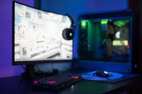 High-tech gaming setup featuring a curved monitor, RGB keyboard, and vibrant lighting. – AW2725DF custom resolution no