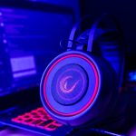 Close-up of gaming headset with neon lighting, placed next to a laptop. Perfect for tech and gaming themes. – gaming headsets for pc