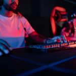 Two focused gamers in a neon-lit arena, wearing headphones and gaming intensely. – best gaming keyboards 2026