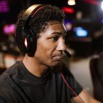 A young man wearing a headset intensely focused on gaming in a lively eSports arena. – best xbox gaming headset