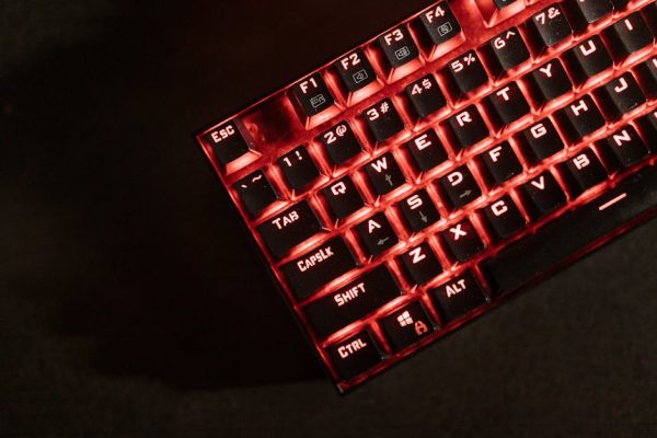 Close-up view of a red illuminated mechanical gaming keyboard in a dark room. – budget-friendly mechanical keyboard guide
