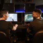 Two men engaged in an exciting gaming session in a modern cyber cafe.