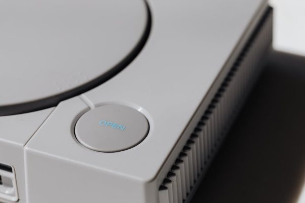 Detailed shot of a classic Sony PlayStation, highlighting the iconic open button and retro design. – console edition vs standard
