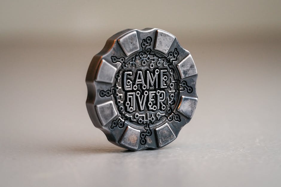 Detailed image of a metal coin with 'Game Over' text, featuring intricate circuit-like designs.
