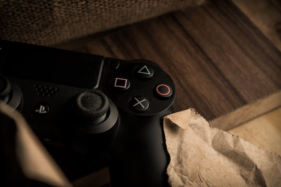 A close-up of a PlayStation gaming controller resting on a wooden surface with a rustic feel. – Fragmentary Order Official Announcement