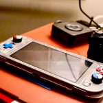 A portable gaming console beside a digital camera showcases modern entertainment and technology setup. – gaming collections worth the