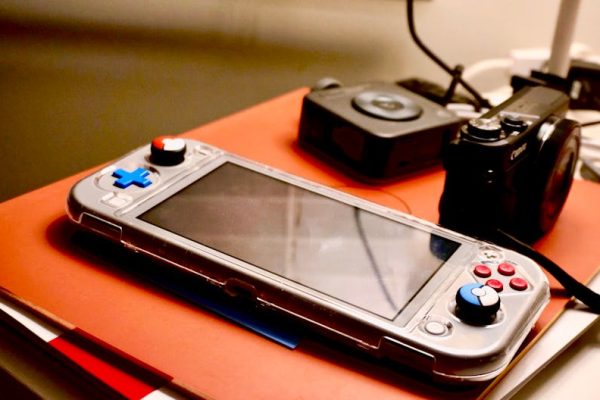 A portable gaming console beside a digital camera showcases modern entertainment and technology setup. – gaming collections worth the