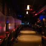 A dimly lit gaming arcade with neon lights and computers, creating a futuristic atmosphere. – gaming evolution she's come