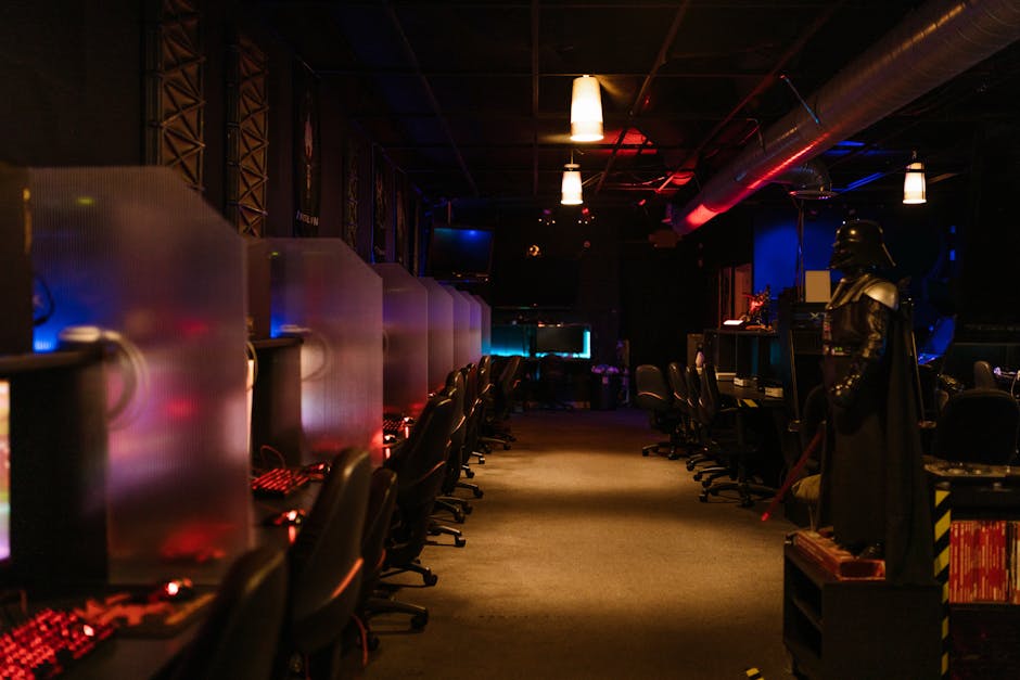 A dimly lit gaming arcade with neon lights and computers, creating a futuristic atmosphere. – gaming evolution she's come