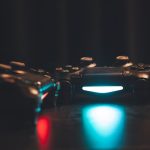 Close-up of glowing gaming controllers on a dark surface, creating a moody ambiance. – gaming hardware explosion concerns