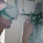 Young man engaging with virtual reality headset indoors, experiencing immersive technology. – google wearable review