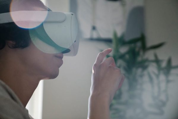 Young man engaging with virtual reality headset indoors, experiencing immersive technology. – google wearable review