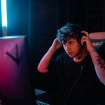 Tattooed man focused on gaming with headset at night. – Halo director accusations gaming
