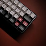 A detailed shot of a mechanical keyboard showcasing colorful and unique keycaps in dim lighting.