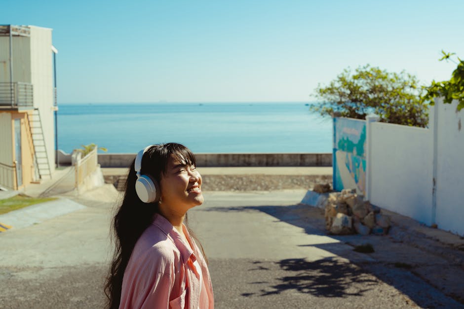 A young woman with headphones enjoys a sunny day by the sea in Bình Thuận, Vietnam.
