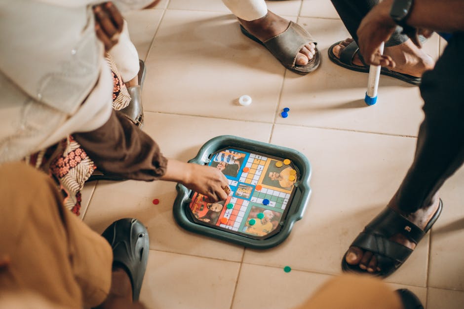 Group of children playing board game indoors on a tiled floor, focused on the game pieces. – Ludum Dare 59 impact