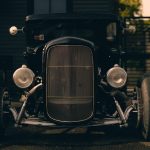 Front view of a classic vintage car parked in an urban setting with a moody atmosphere. – Mafia Trilogy Steam Discount