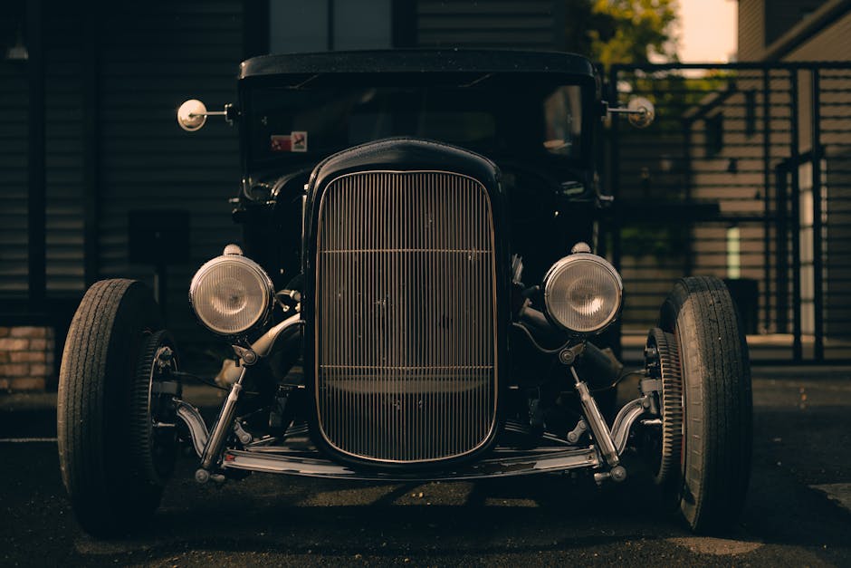 Front view of a classic vintage car parked in an urban setting with a moody atmosphere. – Mafia Trilogy Steam Discount