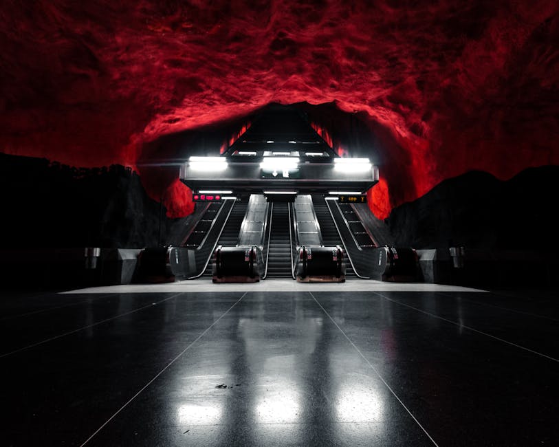 Captivating image of lit escalators at Solna Centrum Station, Stockholm with red cave-like ceiling.
