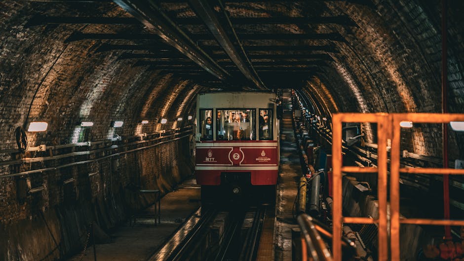 A vintage red tram travels through a historic underground tunnel, offering a unique transportation experience.