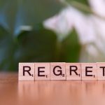 Wooden letter tiles forming the word 'Regret' on a blurred background, symbolizing emotions. – MicroSlop consequences and impact