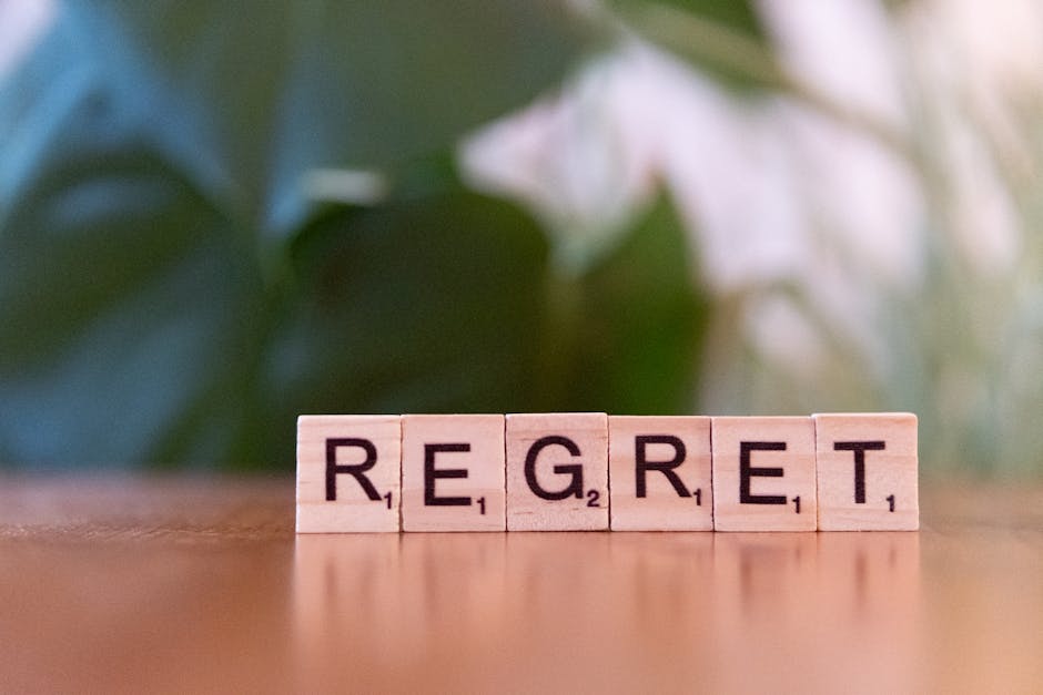Wooden letter tiles forming the word 'Regret' on a blurred background, symbolizing emotions. – MicroSlop consequences and impact