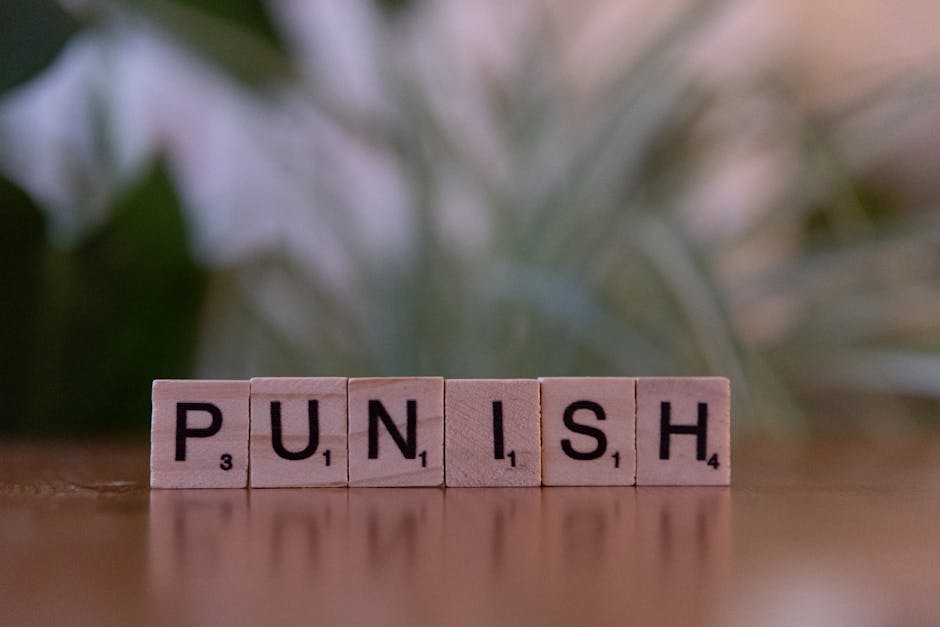 Scrabble tiles spelling 'punish' against a blurred natural background.