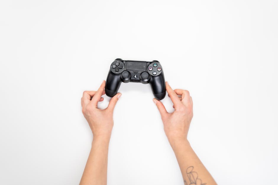 Top view of hands holding a black gaming controller against a white background. – left-handed controls in modern games