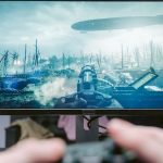 A person playing a video game on a high-resolution monitor, showcasing a war-themed landscape. – NVIDIA warranty claims 1000%