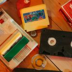 Vintage gaming console with cartridges and VHS tape on wooden surface, nostalgic theme. – preventing dust buildup in