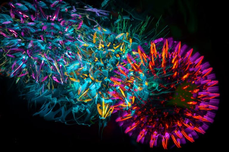 Colorful abstract light patterns with vibrant neon hues on a black background. – Pulsar X2N Crazylight Mini Gaming Mouse Review