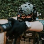 Soldier equipped with tactical gear and helmet in a ready stance outdoors. – Ready or Not franchise