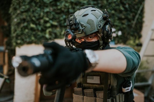 Soldier equipped with tactical gear and helmet in a ready stance outdoors. – Ready or Not franchise