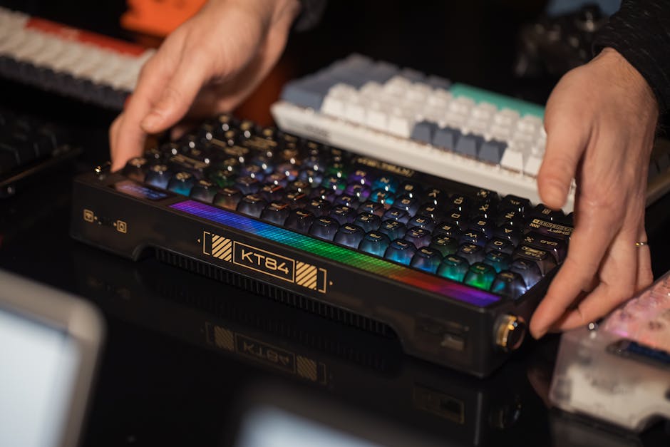 Hands adjusting an RGB mechanical keyboard among other keyboards on a desk. – split keyboard collection