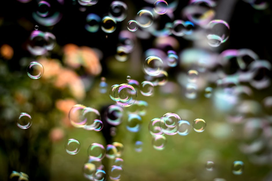 Colorful soap bubbles floating with a blurred nature background.