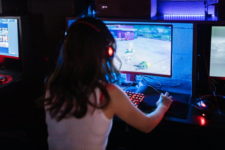 Female gamer focused on playing a competitive online game with RGB keyboard and headphones.