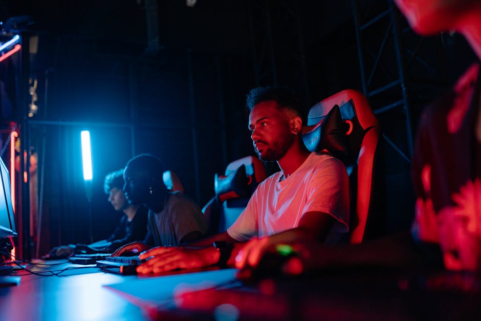 Gamers focused on their screens in a vibrant, dimly lit gaming environment. – esports titles, gaming longevity,